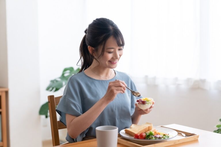 Woman,Eating,Breakfast,In,The,Living,Room